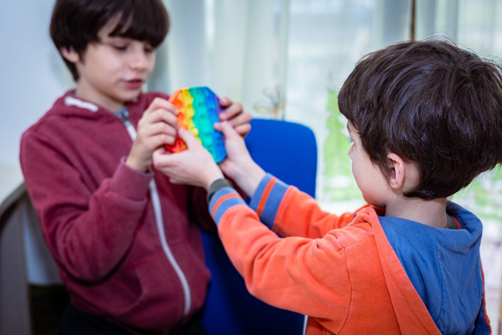Two children playing with a rainbow sensory toy
